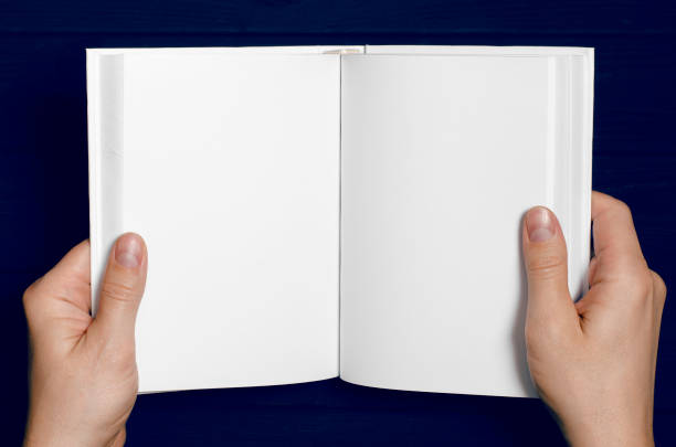 istock Men's hands hold a white book with clean pages 1199237491