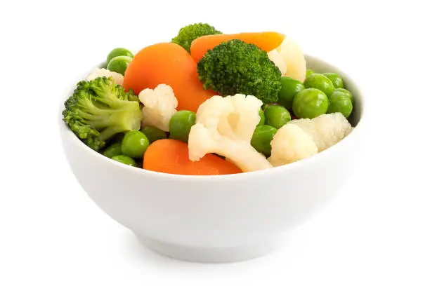 Mixed vegetables in white ceramic bowl isolated on white.