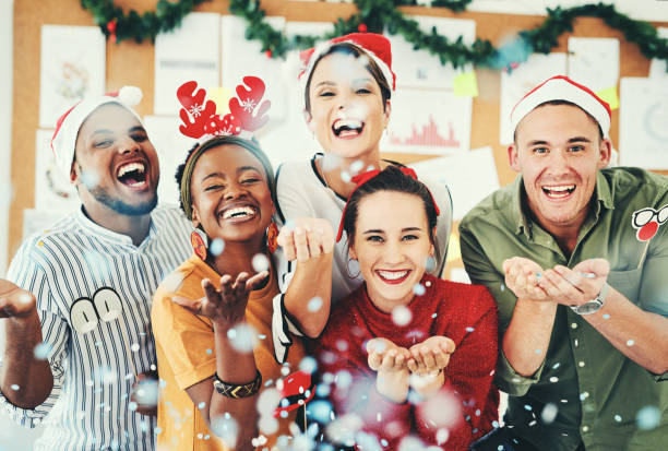 Christmas party vibes! Shot of a group of creative businesspeople celebrating and having fun together at their office Christmas party office christmas party stock pictures, royalty-free photos & images