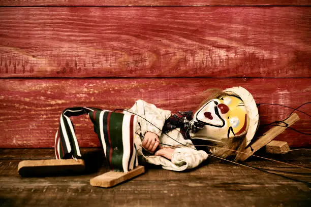 Photo of old marionette on a wooden surface, filtered