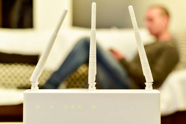 istock wireless router and young man using a smartphone 1199239739