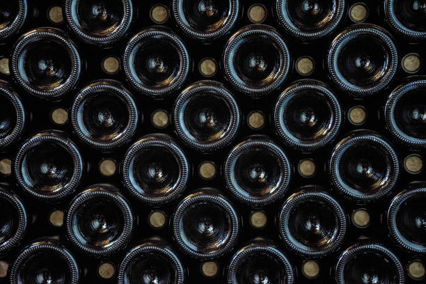 줄지어 늘어선 다크 와인 병 - bottling plant winery wine industry 뉴스 사진 이미지