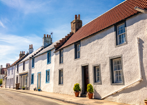 A row of old fashioned cottages on a street near the sea, in the Scottish seaside town of Elie, Fife.