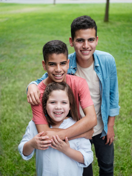 istock Happy siblings standing in line and smiling at camera 1199248407