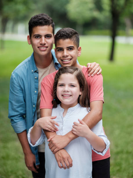istock Cute mexican siblings standing in line and looking at camera 1199248417