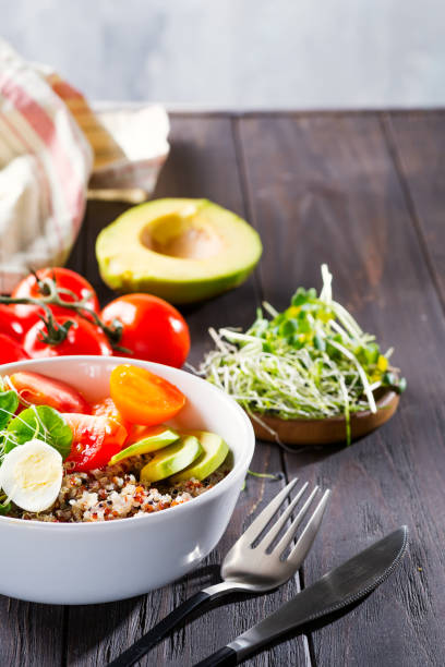 istock Vegetarian breakfast with quinoa, eggs, microgreen and vegetables, green tea with mint on a dark wooden table, flat lay 1199250010