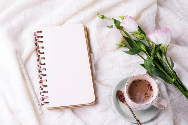 istock Having a cup of coffee , flowers eustoma and notebook on blanket in bed. Holiday concept 1199250220