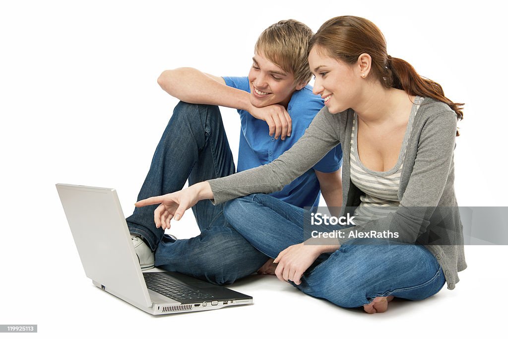 Giovane coppia con un computer portatile - Foto stock royalty-free di Abbigliamento casual