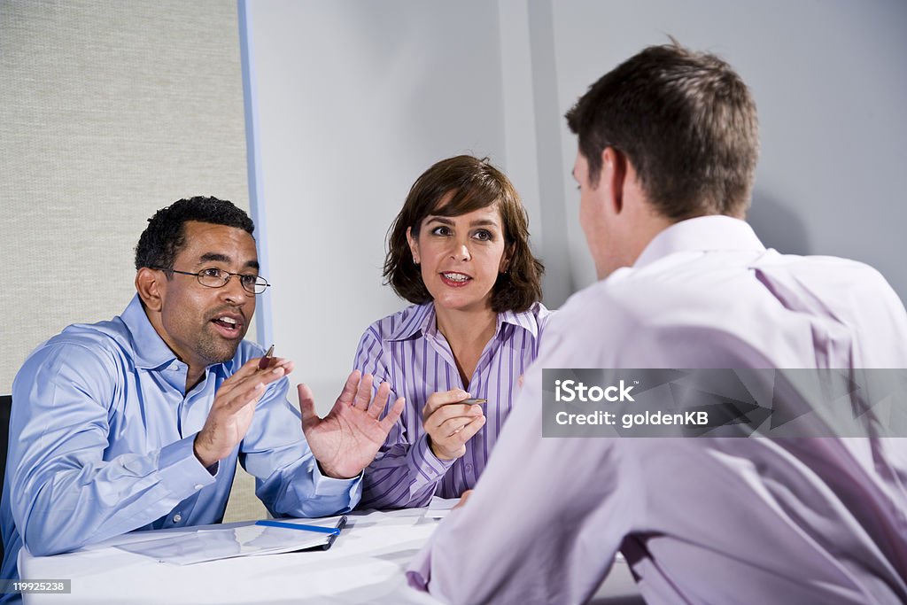 Three mid-adult people sitting at table meeting  30-39 Years Stock Photo