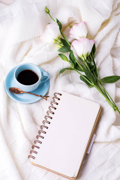 istock Having a cup of coffee , flowers eustoma and notebook on blanket in bed. Holiday concept 1199254192
