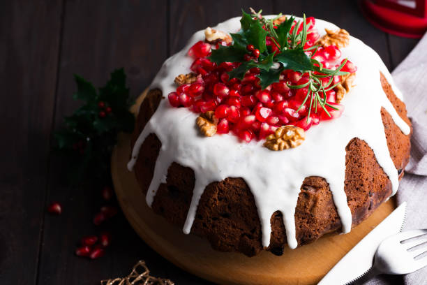 istock Christmas chocolate cake with white icing and pomegranate kernels on a wooden dark background with red lantern 1199254301