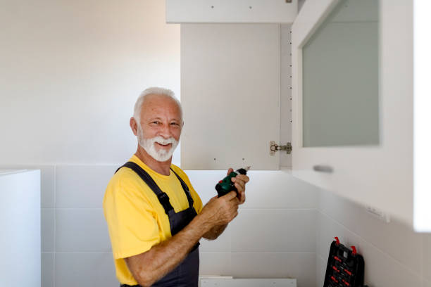 istock Elderly Man With an Electric Drill in His Hands Assembles the Kitchen 1199254479