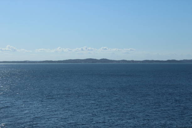 istock blue ocean with mountain silhouettes on horizon and infinite blue sky 1199254954