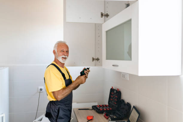 istock Elderly Man With an Electric Drill in His Hands Assembles the Kitchen 1199255801