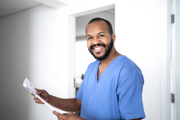 portrait of male nurse with some medical record at hospital - nurse doctor scrubs male imagens e fotografias de stock