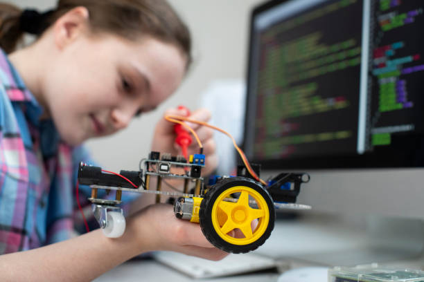 istock Female Pupil Building Robot Car In School Science Lesson 1199260696