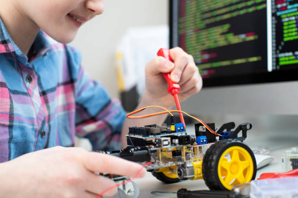 istock Female Pupil Building Robot Car In School Science Lesson 1199261814