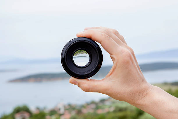 istock Camera lens in woman hand. 1199262252