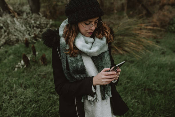 istock Young woman using a Smartphone in a forest 1199266803