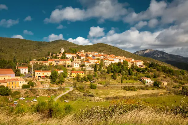 Photo of Cucugnan, a typical small French village in the Corbieres mountains, at the foot of Cathar castle, Queribus, France