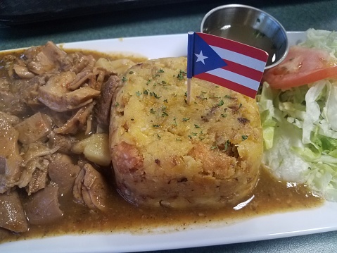 mashed plantain banana and stomach meat with Puerto Rico flag on plate