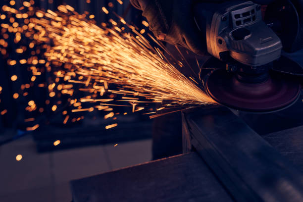 istock Worker cutting metal with grinder. Sparks while grinding iron 1199277427