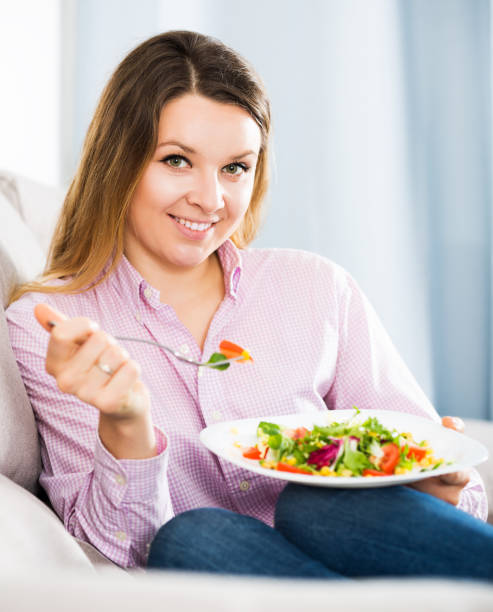 istock Woman tasting fresh green salad 1199277556