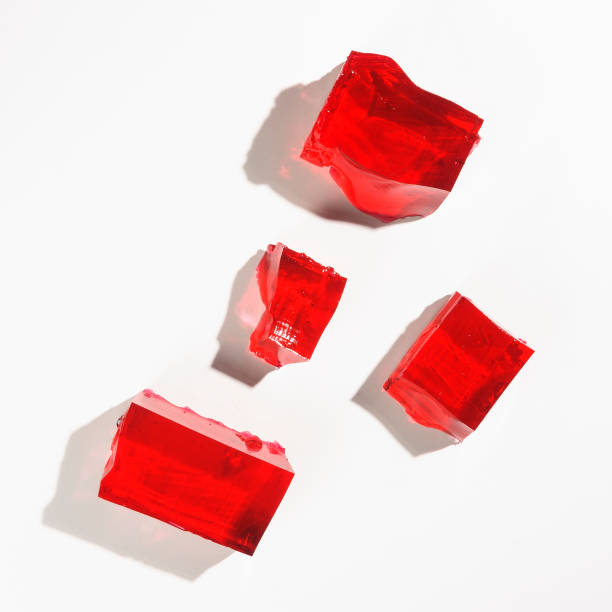 Red jelly Misshapen pieces of red jelly, isolated on a white background gelatin dessert stock pictures, royalty-free photos & images