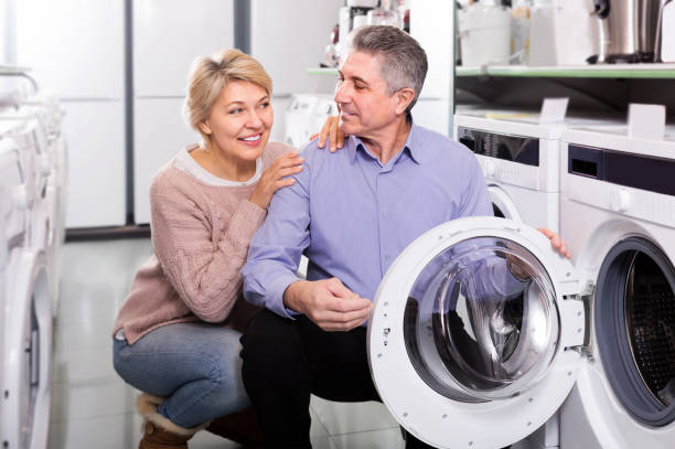 istock Mature couple choosing washing machine in store 1199277980