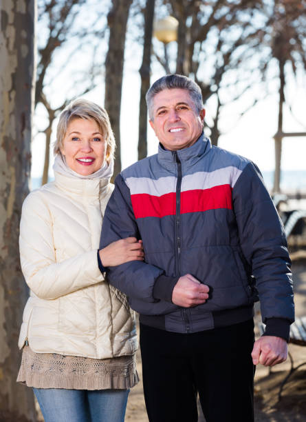 istock Smiling mature couple walk in park 1199278136