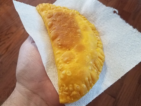 hand holding fried dough on napkin Puerto Rico food