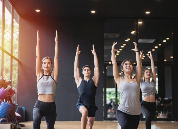 grupa mieszać ludzi rasy praktykujących jogę medytując razem dla zdrowego stylu życia w klubie fitness - yoga class caucasian young adult group of people zdjęcia i obrazy z banku zdjęć