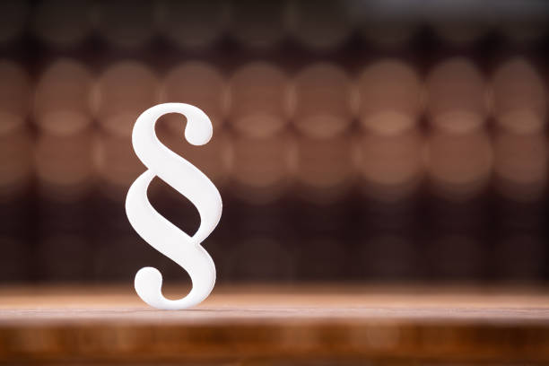 Close-up Of White Paragraph Symbol In Front Of Law Law Books In Courtroom
