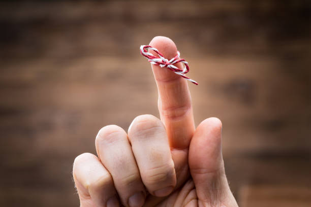 string on person's finger - reminder memories human finger string imagens e fotografias de stock