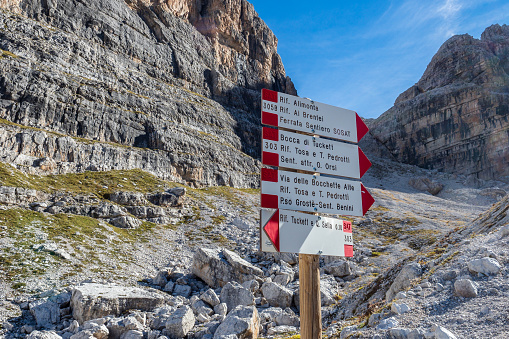 Trekking direction indicators. Tourist paths directions and travel time shown on a traditional direction signs at the Dolomiti mountains, Italy