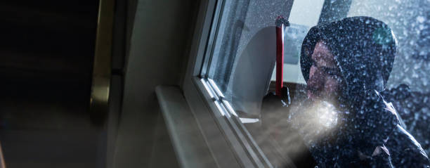 Burglar Looking Into A House Window Burglar With Crowbar And Flashlight Looking Into A House Windows burglary crowbar stock pictures, royalty-free photos & images