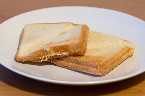 Crispy cheese sandwiches served on white plate.