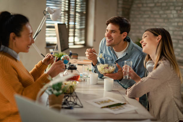 istock Happy entrepreneur communicating with female colleagues during a lunch break. 1199283318
