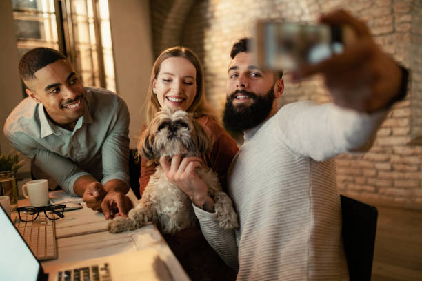 istock Happy freelancers having fun while taking selfie with a dog in the office. 1199283479