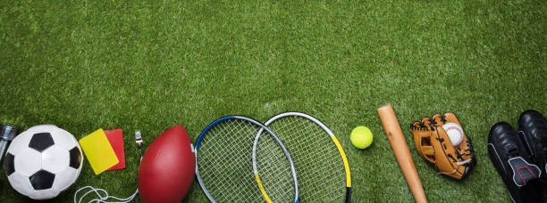 High Angle View Of Various Sport Equipments On Green Grass