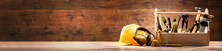 Safety Equipment Near Toolbox With Various Worktools On Wooden Surface