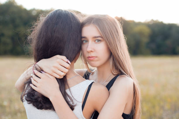 istock Two young women hugging outdoors 1199288447