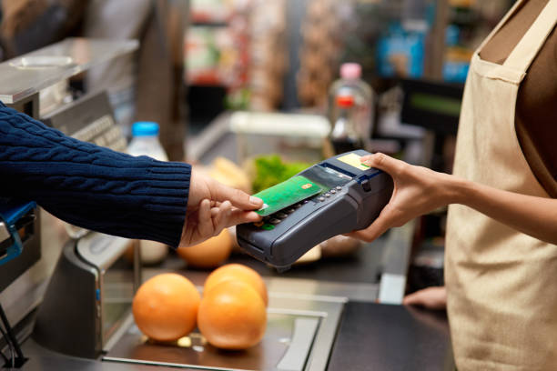 Young adult man paying for shopping in supermarket stock photo