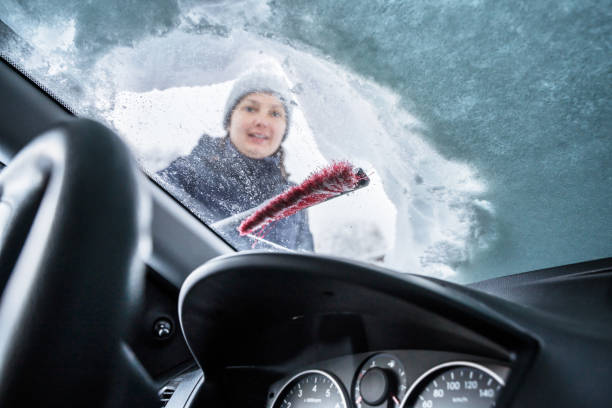 istock Woman Cleaning Car From Snow 1199289129