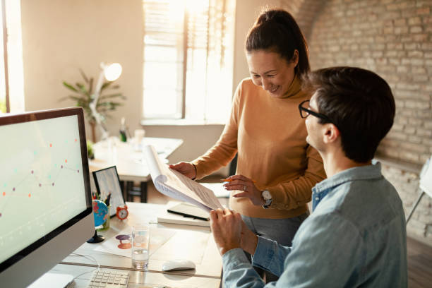 istock Happy entrepreneurs going through business plans in the office. 1199289189
