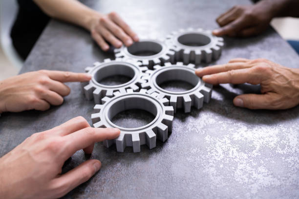 istock Businesspeople Joining Gears On Desk 1199289475