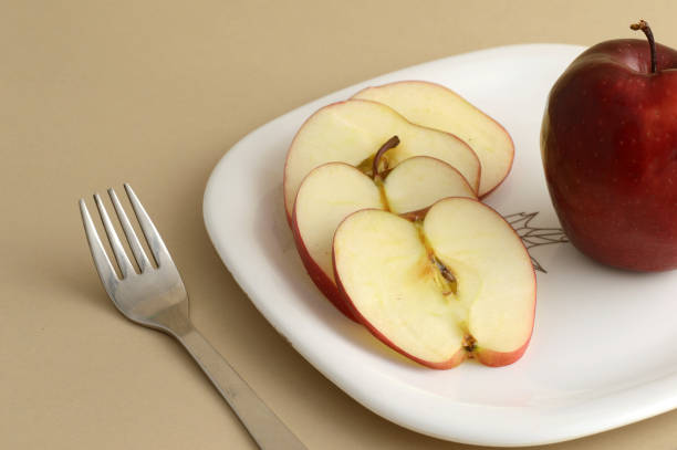 istock Delicious apple and slice in white plate with knife and fork 1199291528