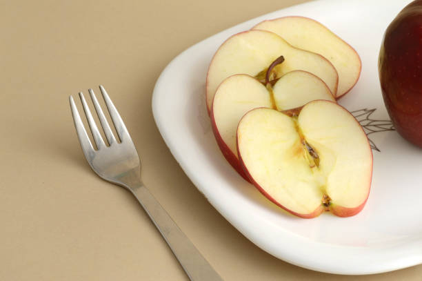 istock Delicious apple and slice in white plate with knife and fork 1199292649