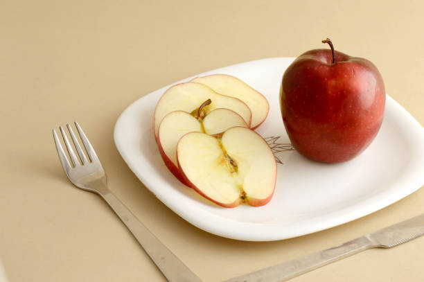 istock Delicious apple and slice in white plate with knife and fork 1199292766