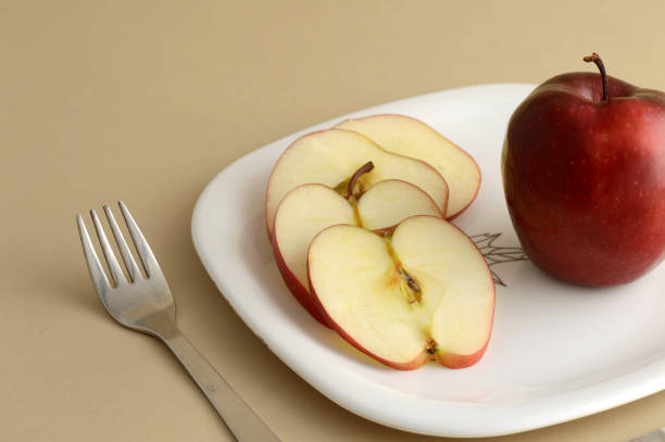 istock Delicious apple and slice in white plate with knife and fork 1199293000